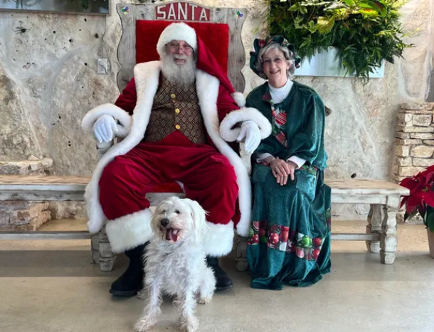 Santa and Mrs. Claus with a white dog